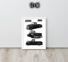 A framed black and white vintage truck art print leaning against a light gray wall on a light wood floor. The print shows three views of a 1954 Jeckone truck, with 'JECKONE' and '1954' printed at the top.